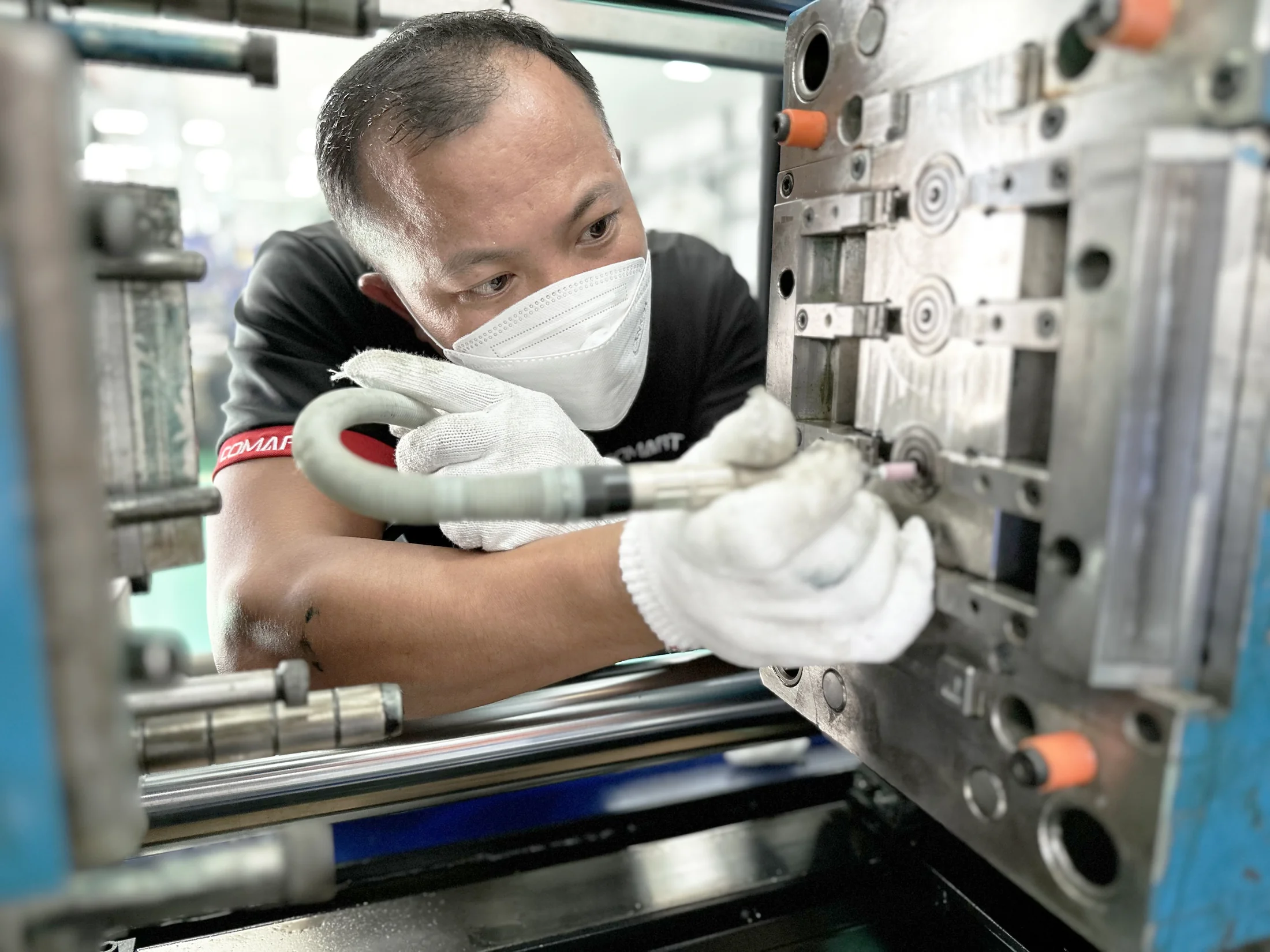 COMART engineer servicing an injection mold on the production floor